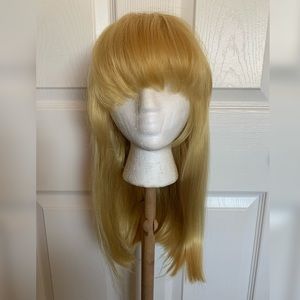 Shoulder Length Blonde Wig with Voluminous Arched Bangs and Strawberry Red Tones